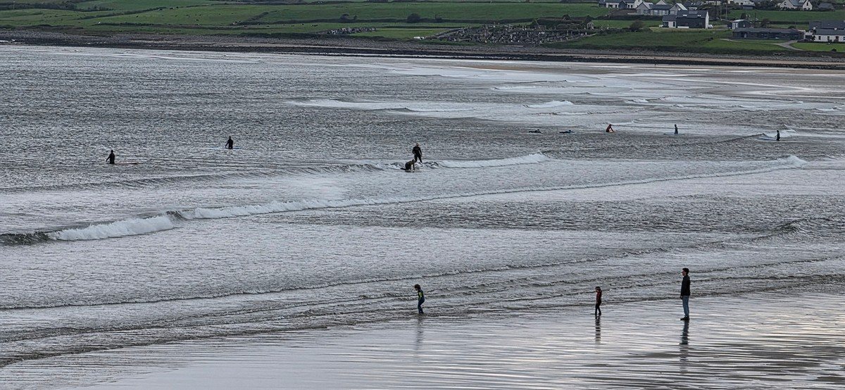 a few beginners in the shallows at the north end of the beach